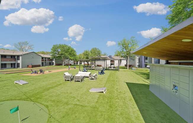 a backyard with tables and chairs on a grass field