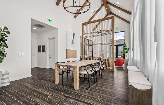 A room with a wooden floor and a long table with chairs.