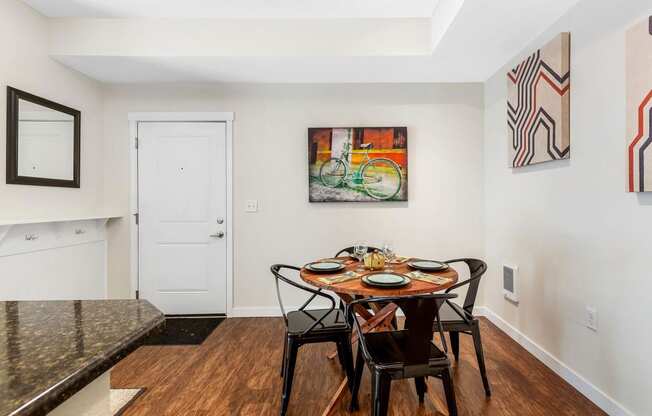 a dining area with a wooden table and chairs and a colorful painting on the wall at Mullan Reserve Apartments, Missoula, 59808