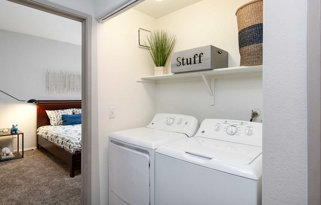 a white washer and dryer in a room with a bedroom