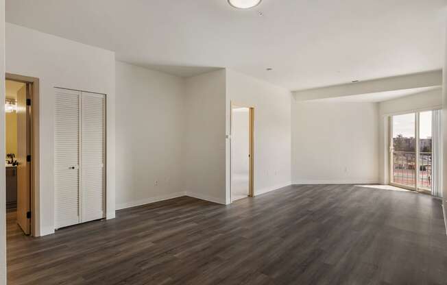 Open style living room with wood flooring, glass doors to private balcony.at Shoreline Village, Richland Washington