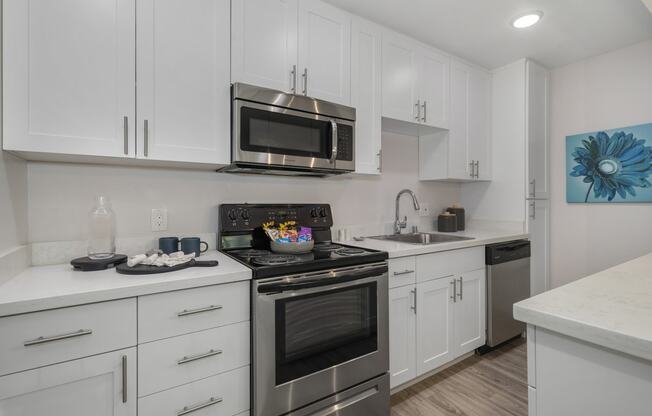 a kitchen with white cabinets and stainless steel appliances