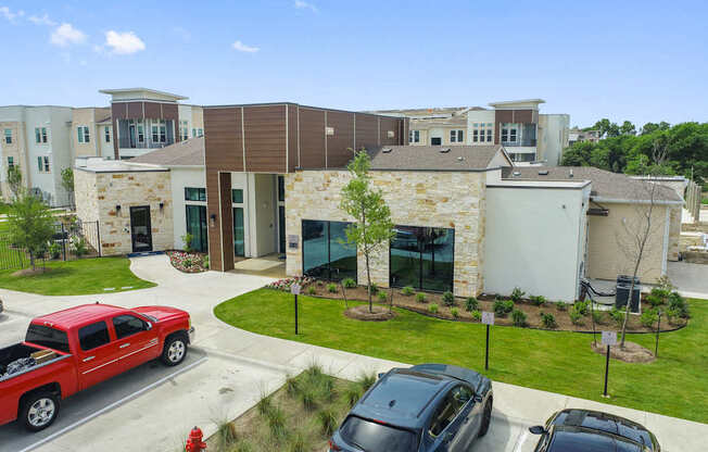 A red pickup truck is parked in front of a building with a stone facade.