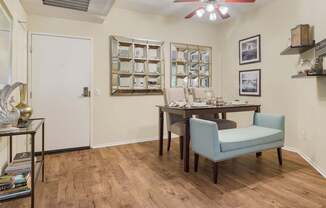 A room with a dining table and chairs.