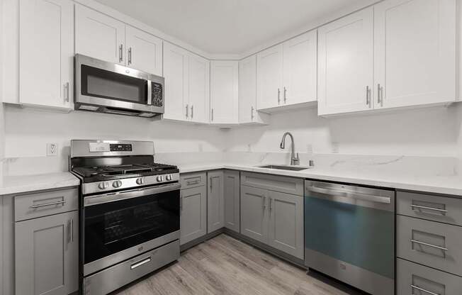 A kitchen with a stove, oven, and microwave.