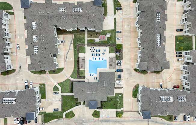 an aerial view of a neighborhood with houses and a pool