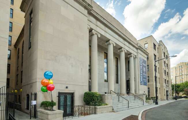 the facade of a building with balloons in front of it