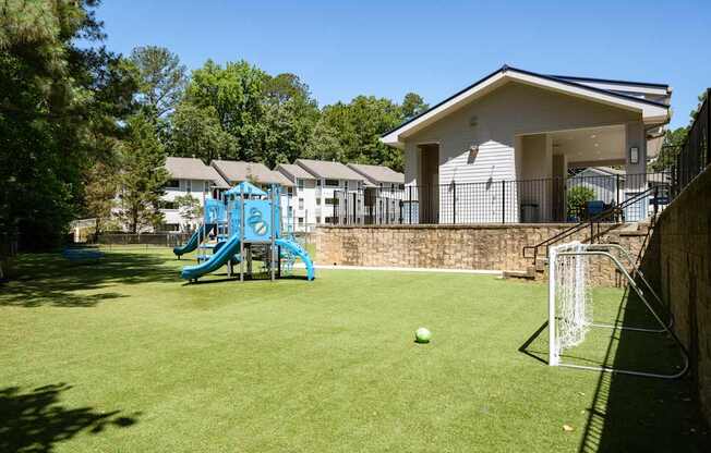 A soccer ball is in front of a goal on a green field.
