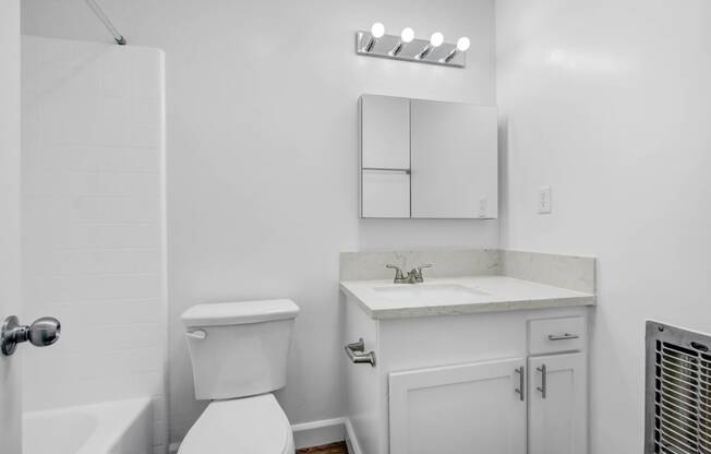 a white bathroom with a toilet and a sink