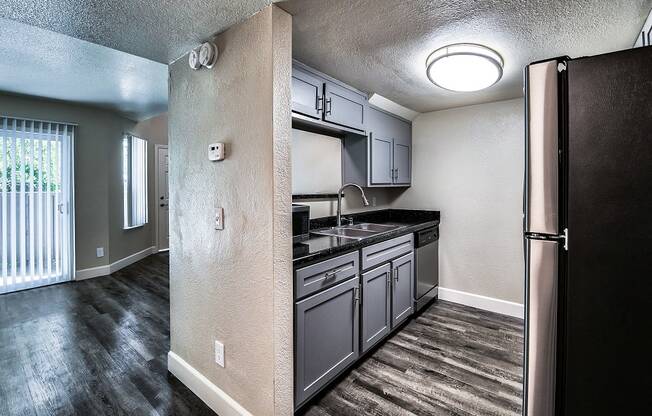 a kitchen with gray cabinets and black countertops