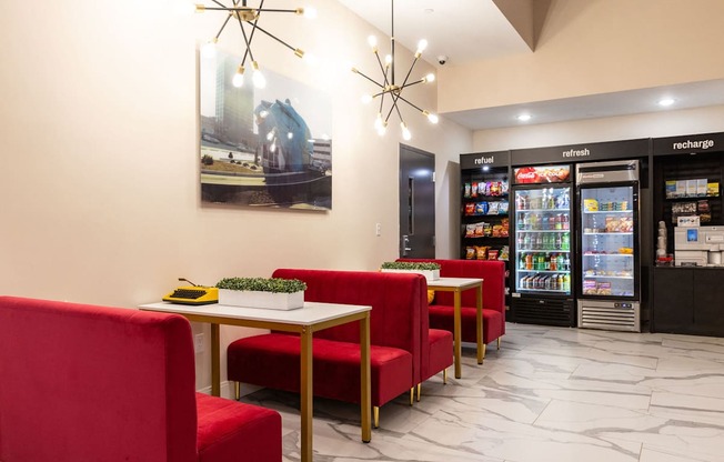 a dining room with red chairs and tables in front of refrigerators