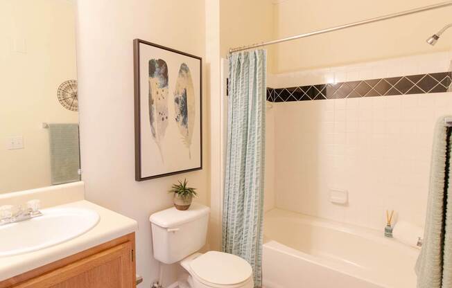 A bathroom with a toilet, sink, and bathtub.