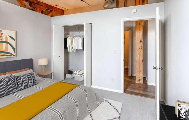 A bedroom with a bed, a lamp, a rug and a painting on the wall.