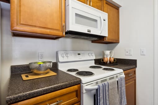 a kitchen with a white stove top oven next to a counter top with a bowl on it