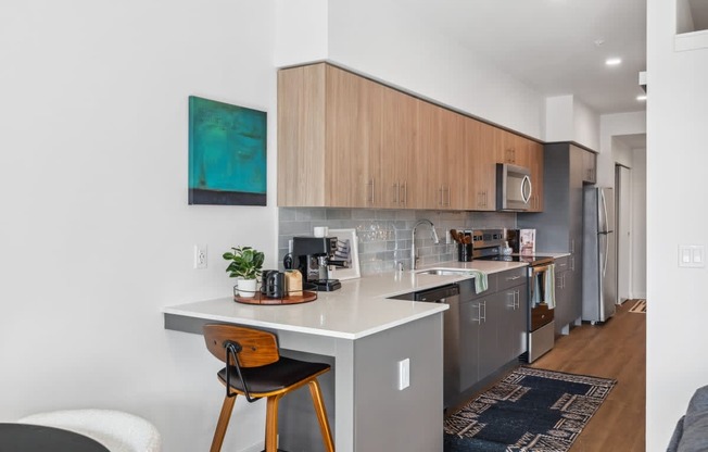 A kitchen with a white countertop and wooden cabinets.