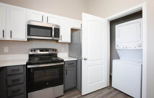 A kitchen with a white oven and microwave.