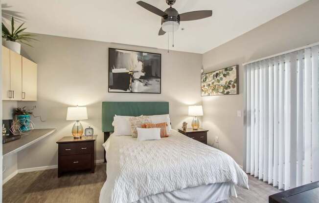 A bedroom with a large bed and a ceiling fan.