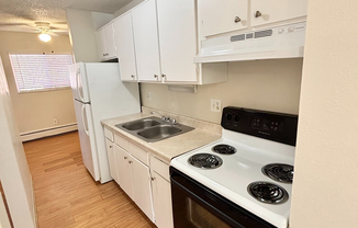 Image Cozy kitchen with sleek white cabinets and modern appliances, featuring a stylish stove and ample natural light.(5)