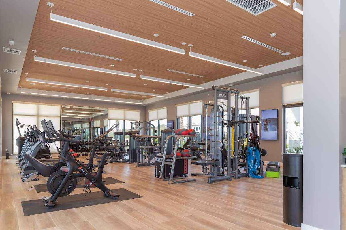 A gym with a variety of equipment including treadmills, weights, and exercise machines at Portofino Vineyards, Fort Myers