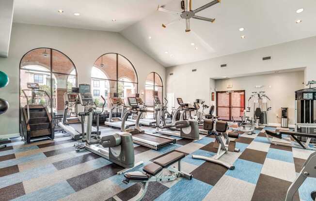 a gym with cardio machines and weights on a checkered floor