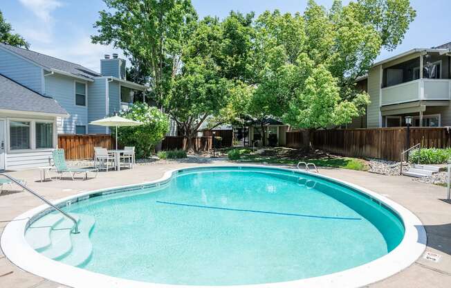 View of gated community pool at Creekside Colony with lounge chairs and seating