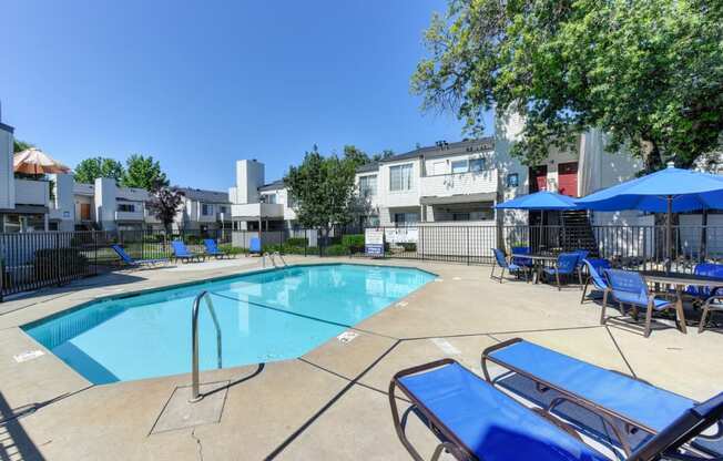 Swimming Pool Lounge Area with bright blue chairs and umbrellas 