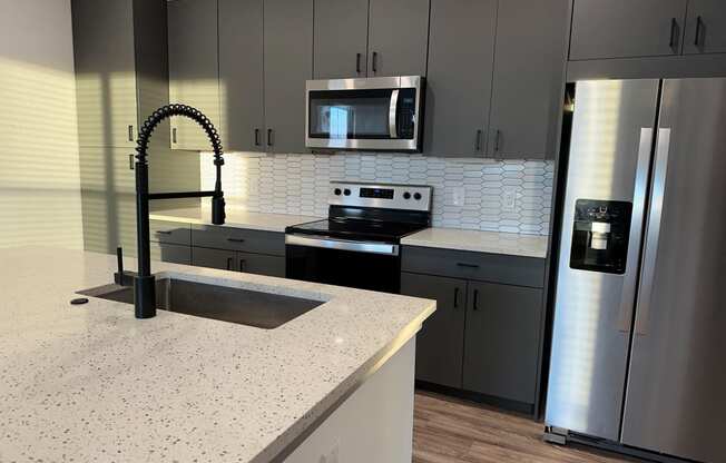 a kitchen with granite counter tops and stainless steel appliances at The Depot, Raymore