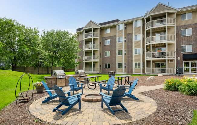 an outdoor patio with blue chairs and a fire pit