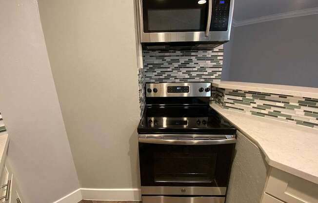 A modern kitchen with a stainless steel oven and microwave.