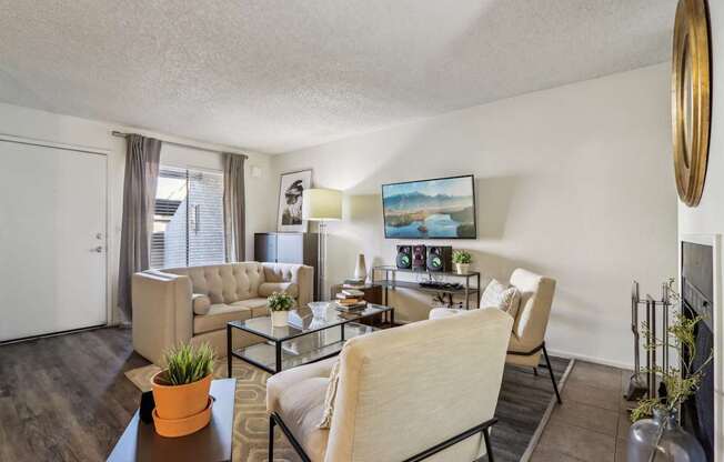 A living room with a couch, chairs, and a coffee table.