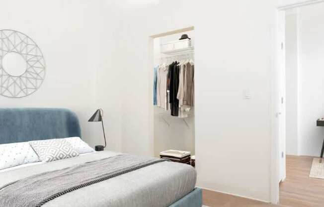 A bedroom with a bed, a lamp, a rug and a wardrobe.