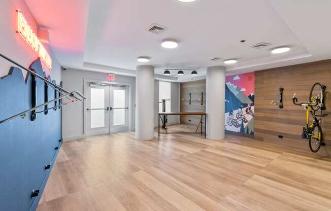 a workout room with a bike rack and a wall with a mural