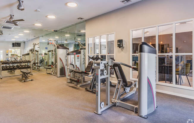 a gym with cardio machines and other exercise equipment in a building