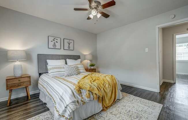 the master bedroom has a comfy bed and a ceiling fan