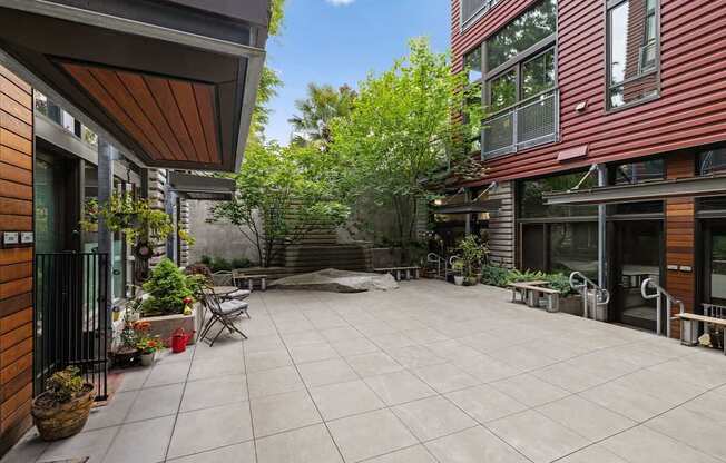 A patio with a table and chairs is surrounded by buildings.