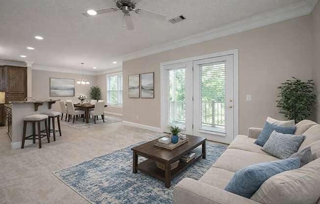 A living room with a beige couch, a wooden coffee table, and a ceiling fan.