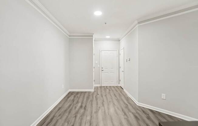 A room with a white door and a light on the ceiling.