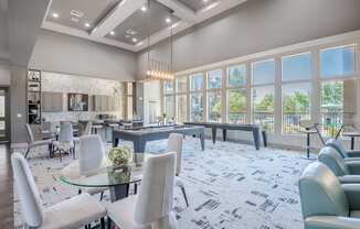 a gathering room with tables and chairs and large windows