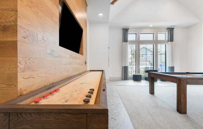 a game room with a shuffleboard table and a pool table