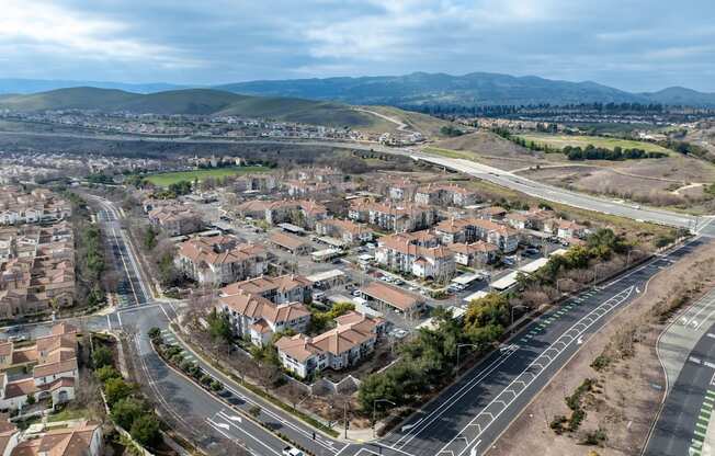 A bird's eye view of a residential area with houses and roads at Cornerstone at Gale Ranch Apartments, California