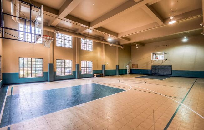 a basketball court in an empty gym with a basketball hoop