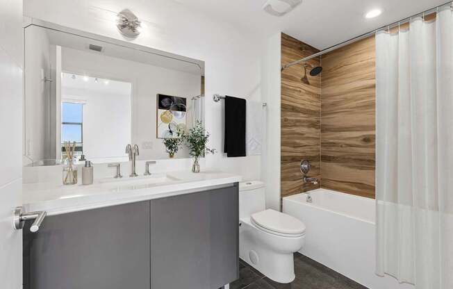 Contemporary apartment bathroom at MB Station with modern vanity, quartz countertop, soaking tub, and stylish finishes in Coral Way, Miami.