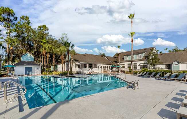 A swimming pool surrounded by trees and buildings.
