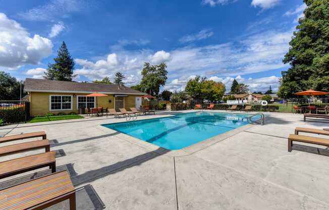 Community swimming pool area and sun deck  with lounge chairs 