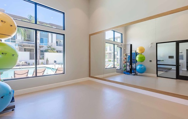 A room with a large mirror and exercise balls.