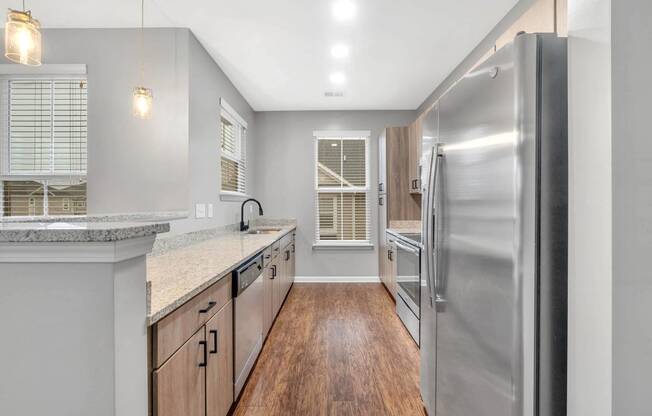 a kitchen with stainless steel appliances and wooden floors