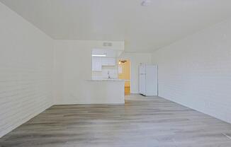 A white kitchen with a wooden floor and white walls.