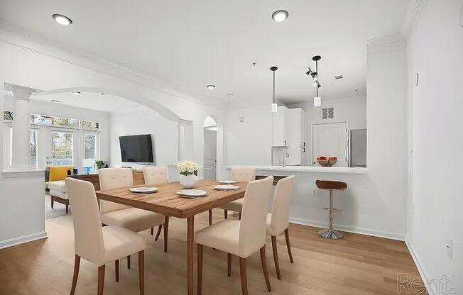 A dining room with a wooden table and chairs.