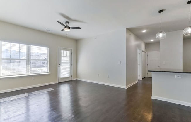 Ashland Farms Living Room with Wood-Style Flooring, Ceiling Fan, and Large Windows Providing Natural Light