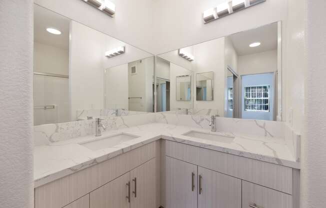 a bathroom with two sinks and a large mirror